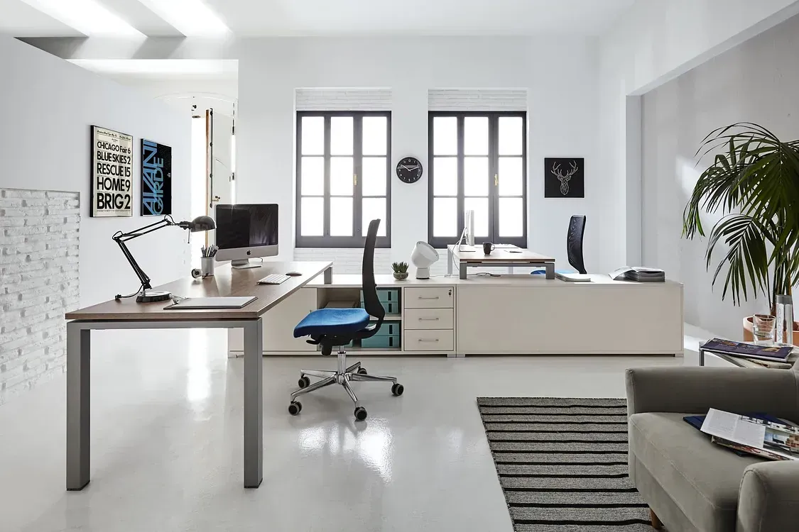 Una sala de estar con un sofá y un escritorio con una computadora encima.