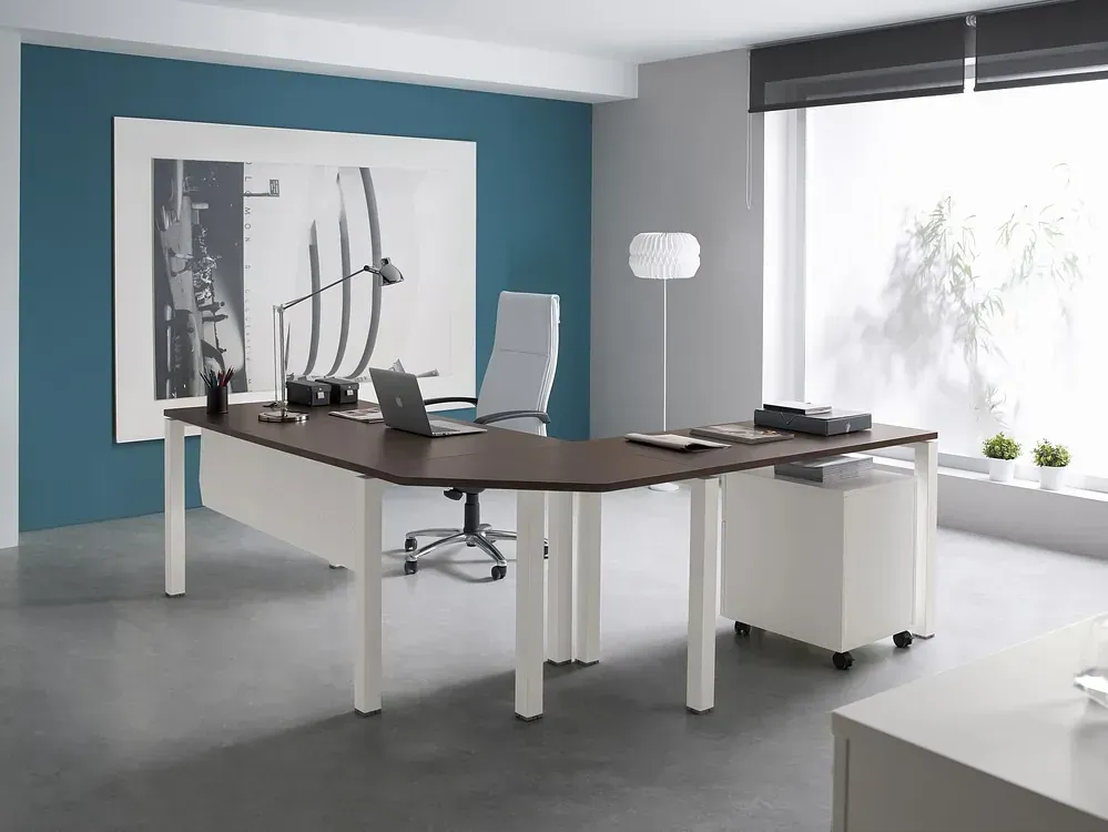 Un escritorio con una computadora portátil encima en una oficina.