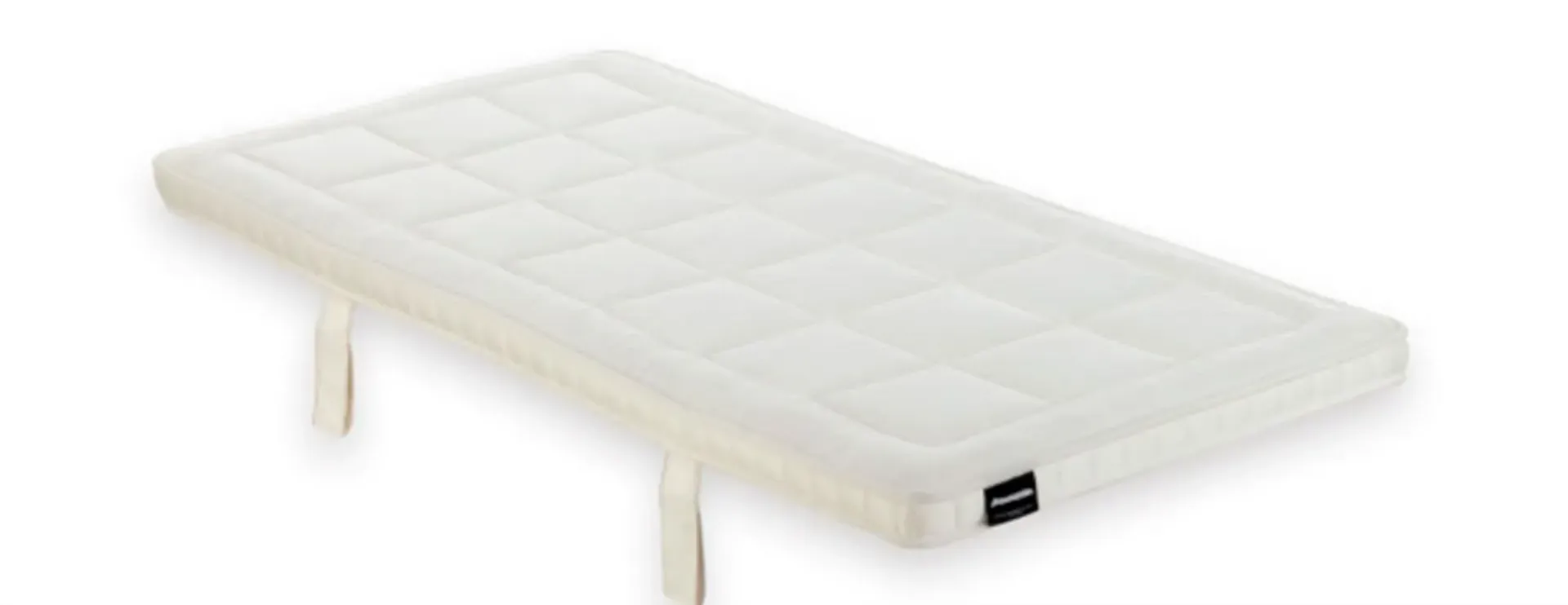 Un colchón blanco está sobre una mesa blanca.