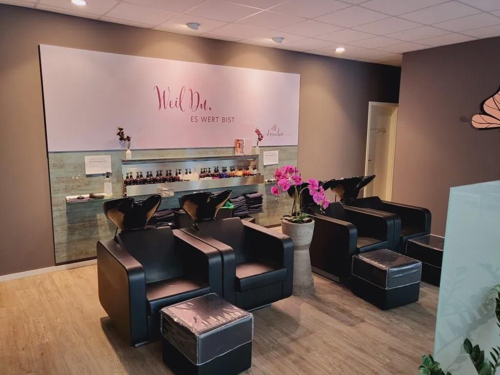 Ein Salon mit Stühlen und Waschbecken und einem Schild mit der Aufschrift 