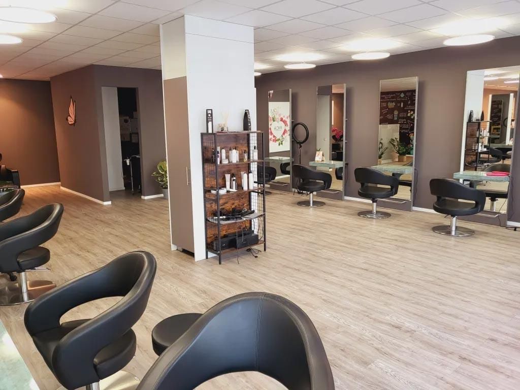 Ein Friseursalon mit vielen Stühlen und Spiegeln