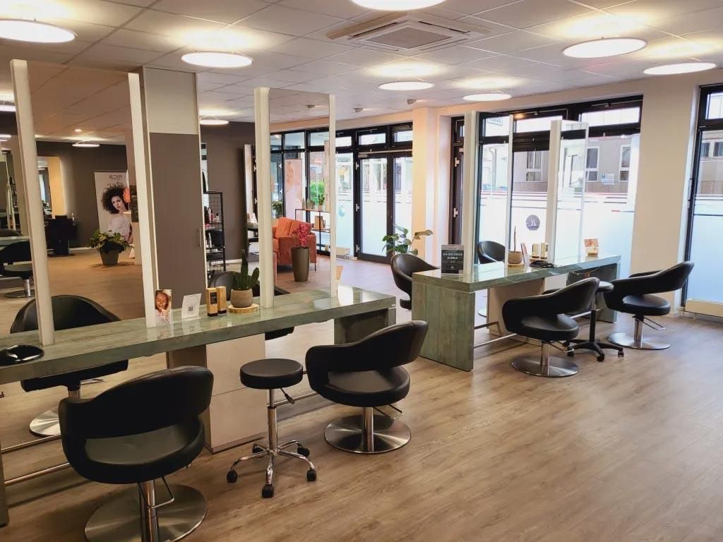 Ein Friseursalon mit vielen Stühlen und Tischen
