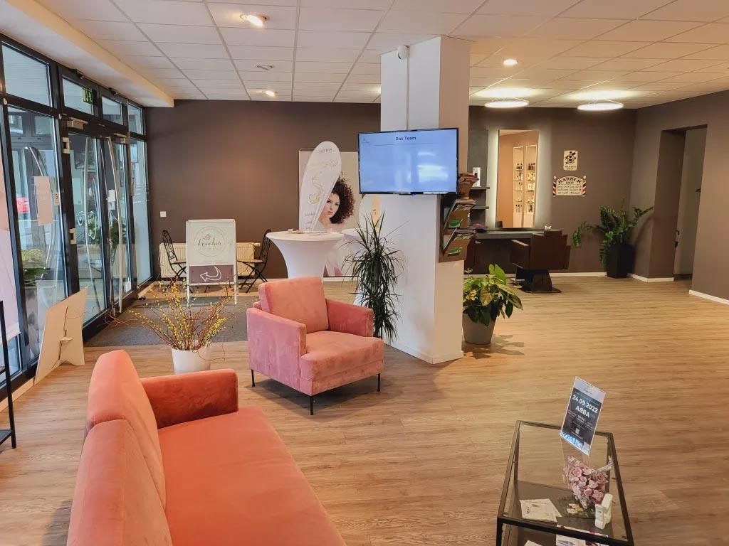 Ein Wohnzimmer mit einer rosa Couch und einem rosa Sessel