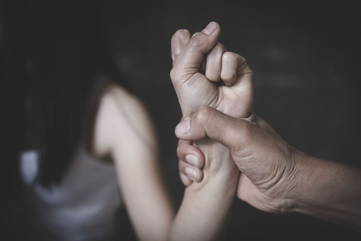 Une main d'homme qui tient le poignet d'une femme