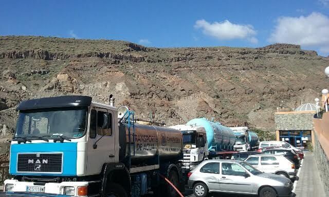 Un camión de carga está estacionado frente a una montaña.