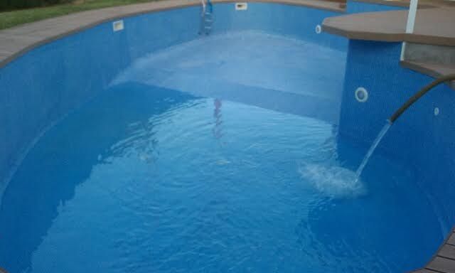 Una piscina azul con una fuente en el medio