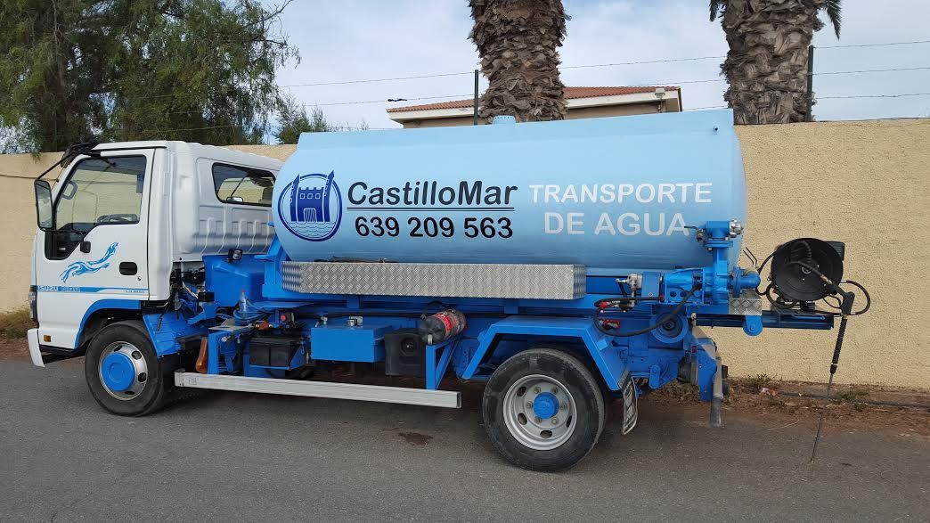 Un camión azul y blanco está estacionado al costado de la carretera.