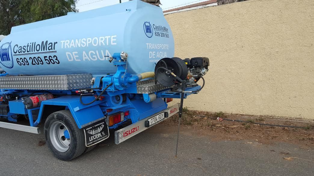 Un camión azul está estacionado al costado de la carretera.