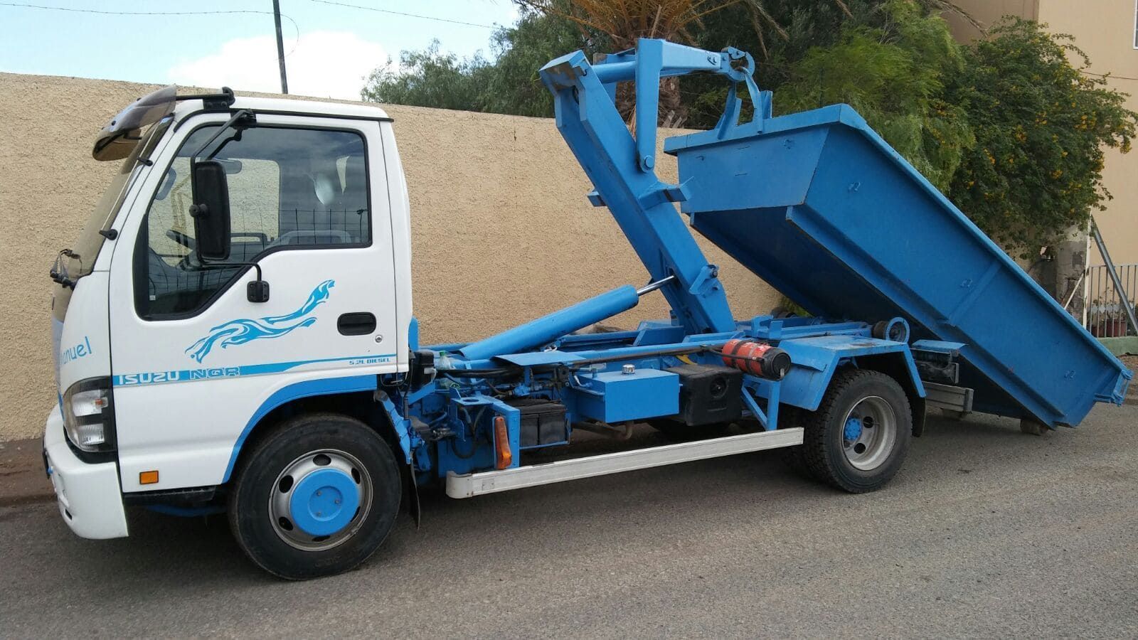 Un camión volquete azul está estacionado al costado de la carretera