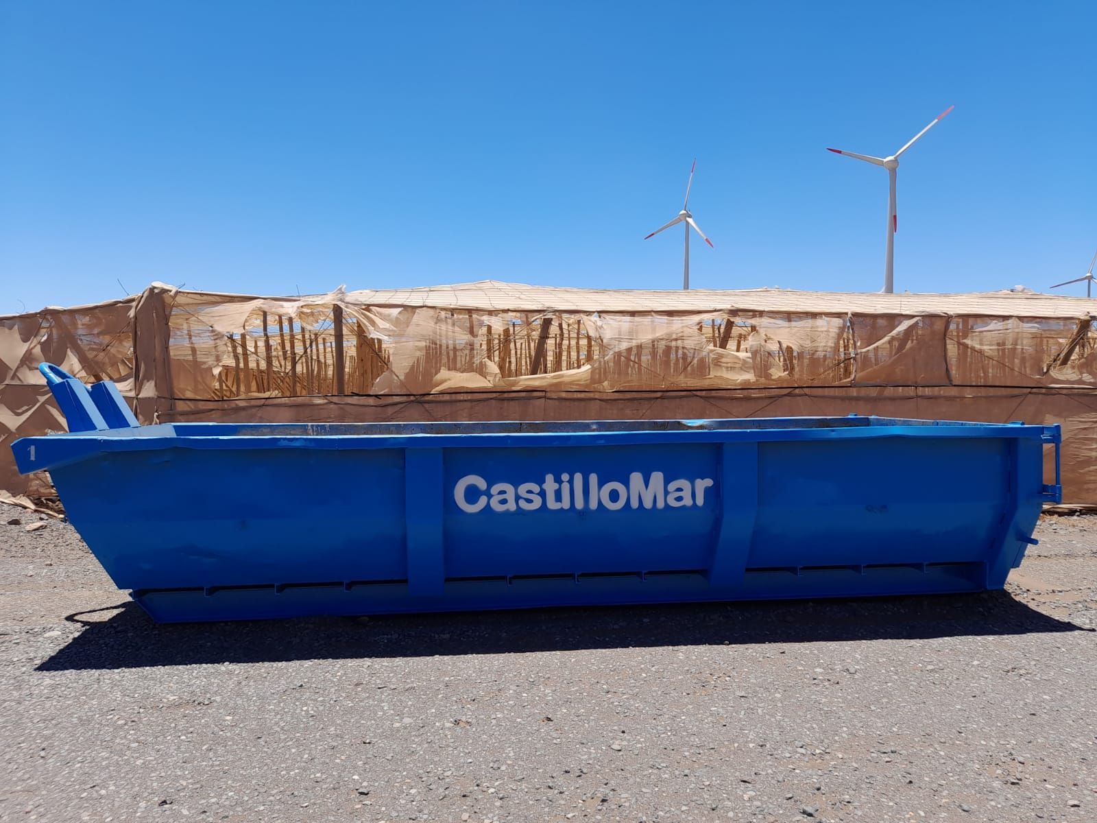 Un contenedor de basura azul con la palabra Castillomar.