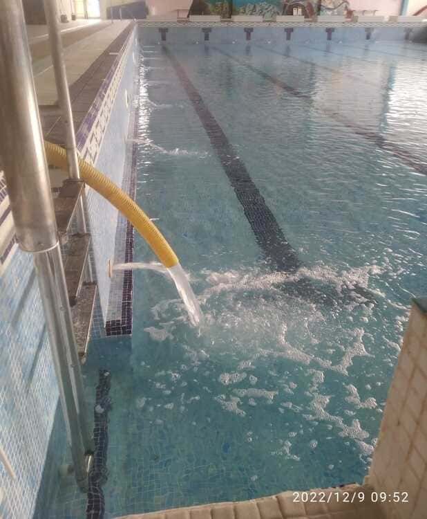 Una piscina con una manguera amarilla que sale de ella.