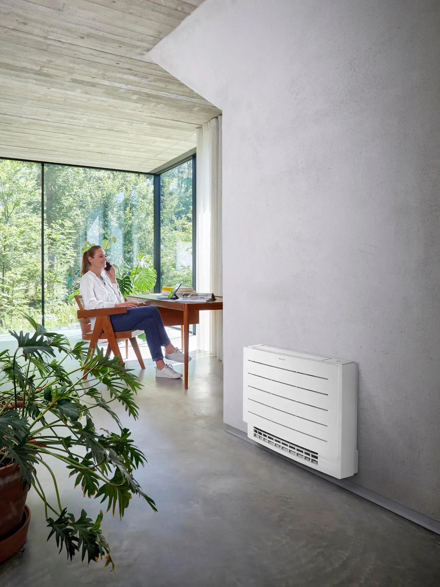 Convecteur de PAC air/air et femme assise au téléphone