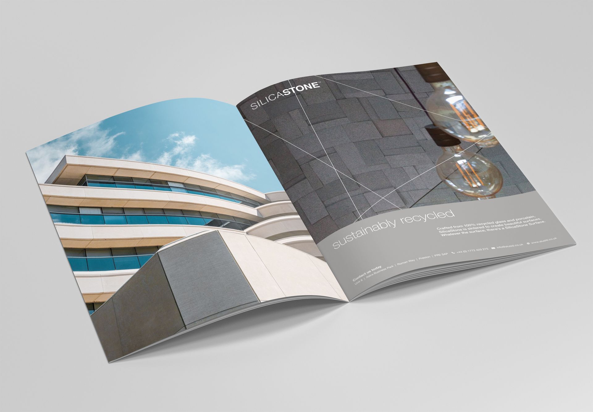 An open brochure on a gray background displays architectural photography of a modern building and interior lighting.