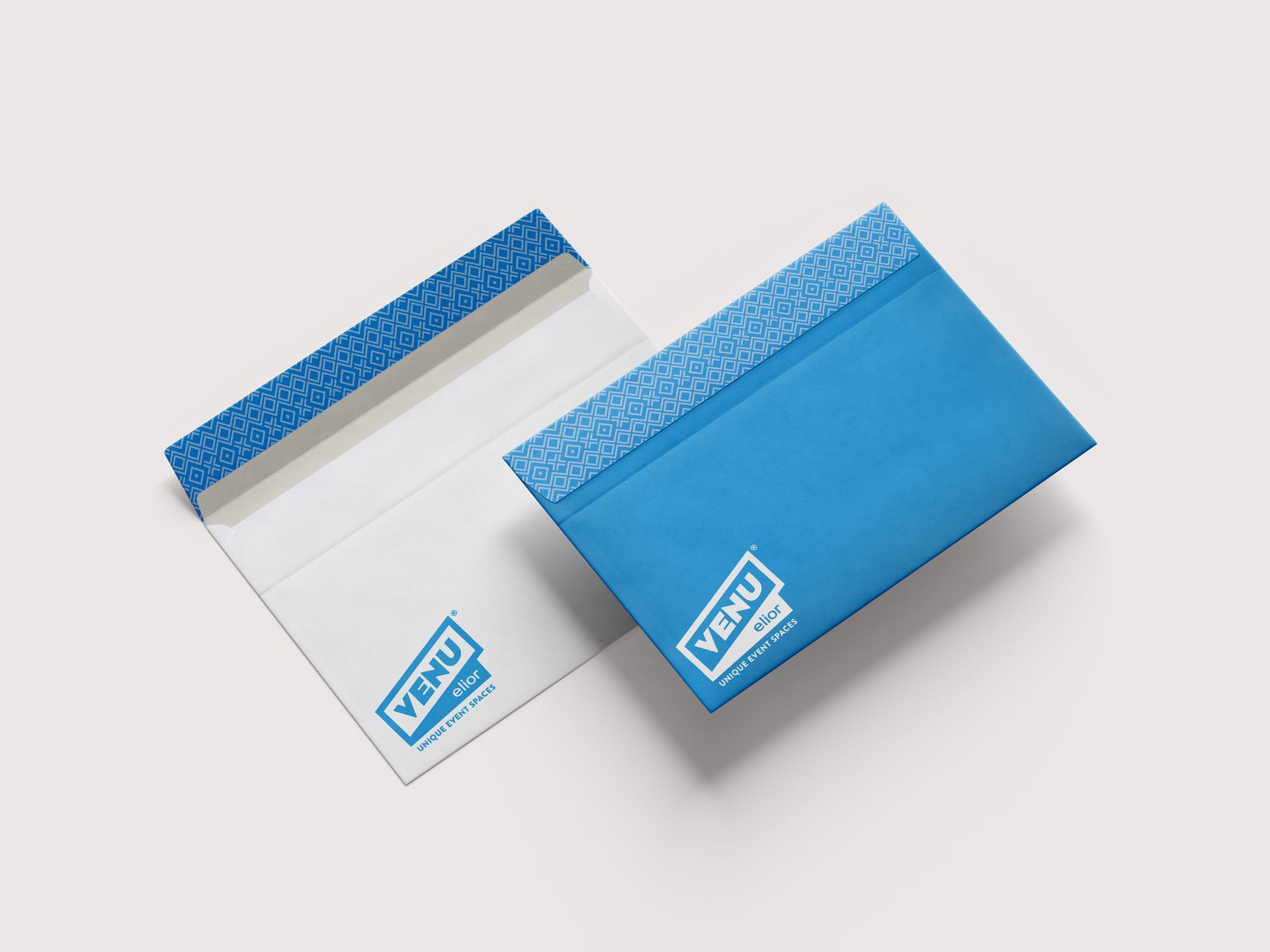 Two blue envelopes, one open and one closed, featuring a patterned top strip and a white 
