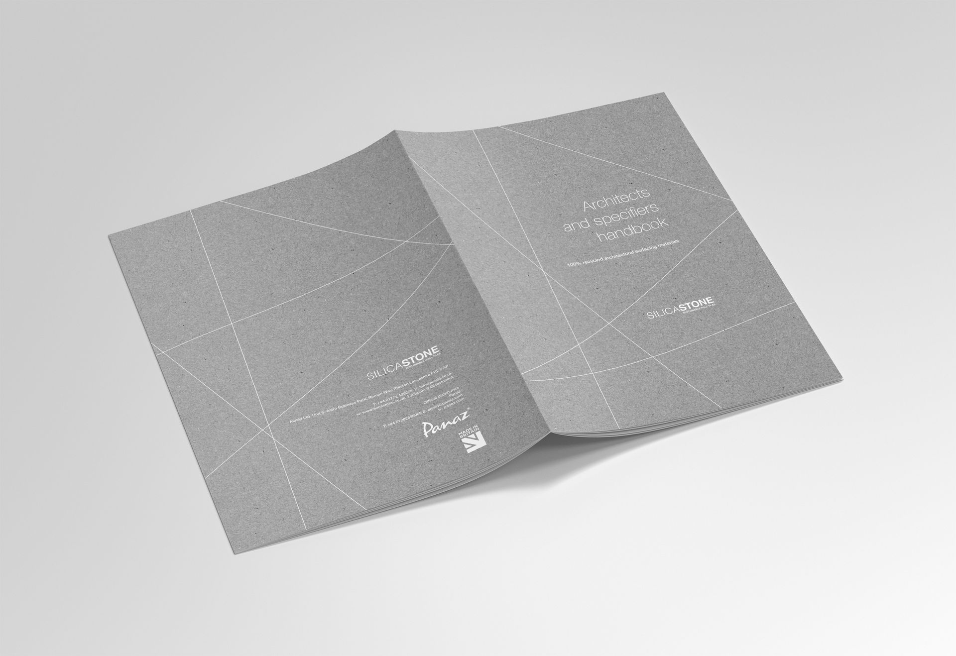 An open, gray, textured card or booklet with white, dotted-line geometric patterns against a plain gray background.