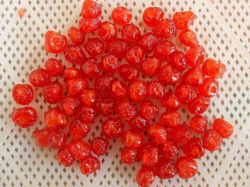 Una pila de cerezas rojas sobre una superficie blanca