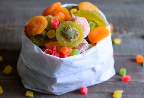 Una bolsa de fruta seca está sobre una mesa de madera.