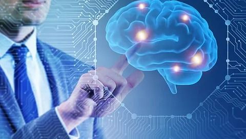 Un hombre con traje y corbata señala un cerebro en una pantalla.