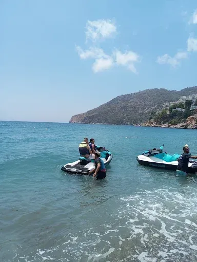 Un grupo de personas están viajando en motos de agua en el océano.