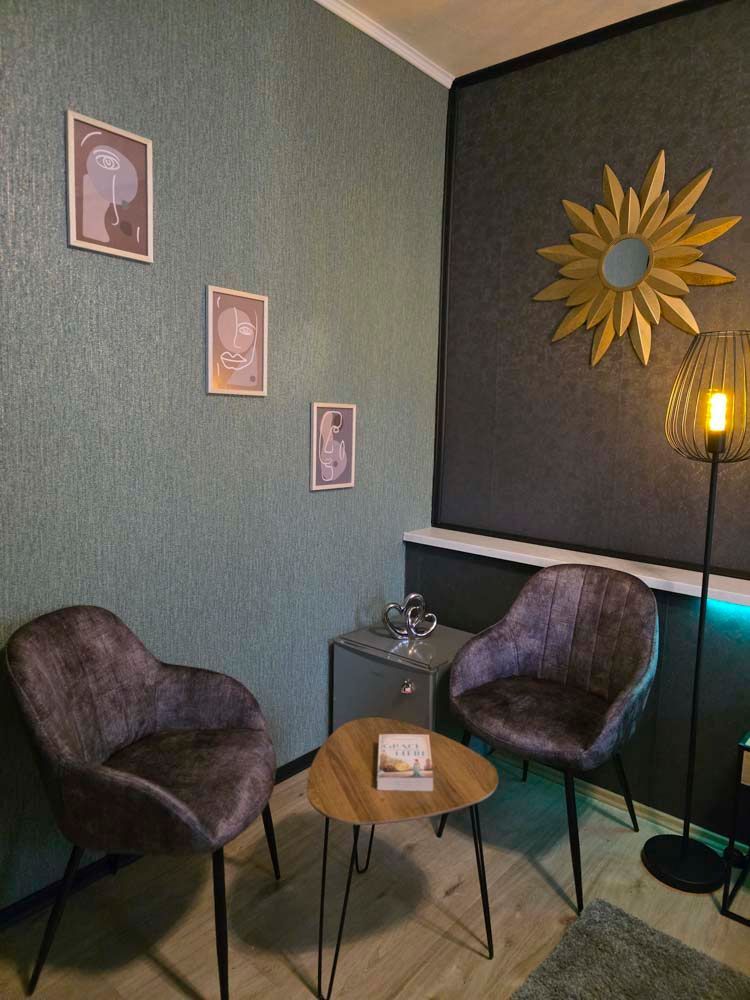 Im Zimmer befinden sich zwei Stühle und ein Tisch.