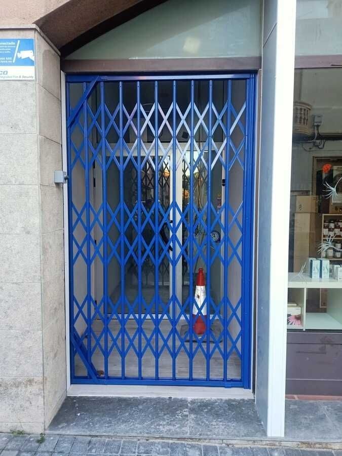 Una puerta azul está cerrada frente a una tienda.