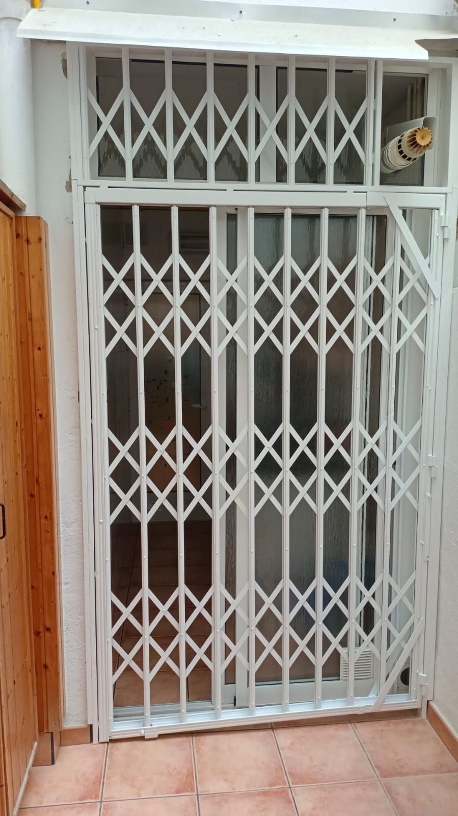 Una puerta blanca está colocada encima de una puerta corrediza de vidrio.