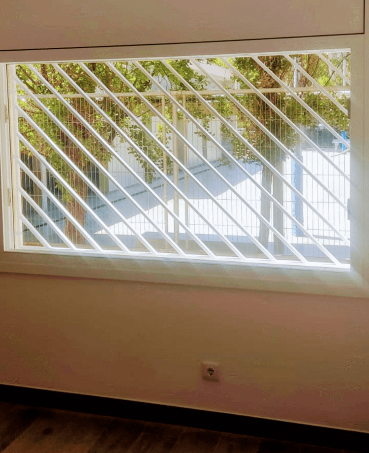 Una ventana con una reja alrededor en una habitación.