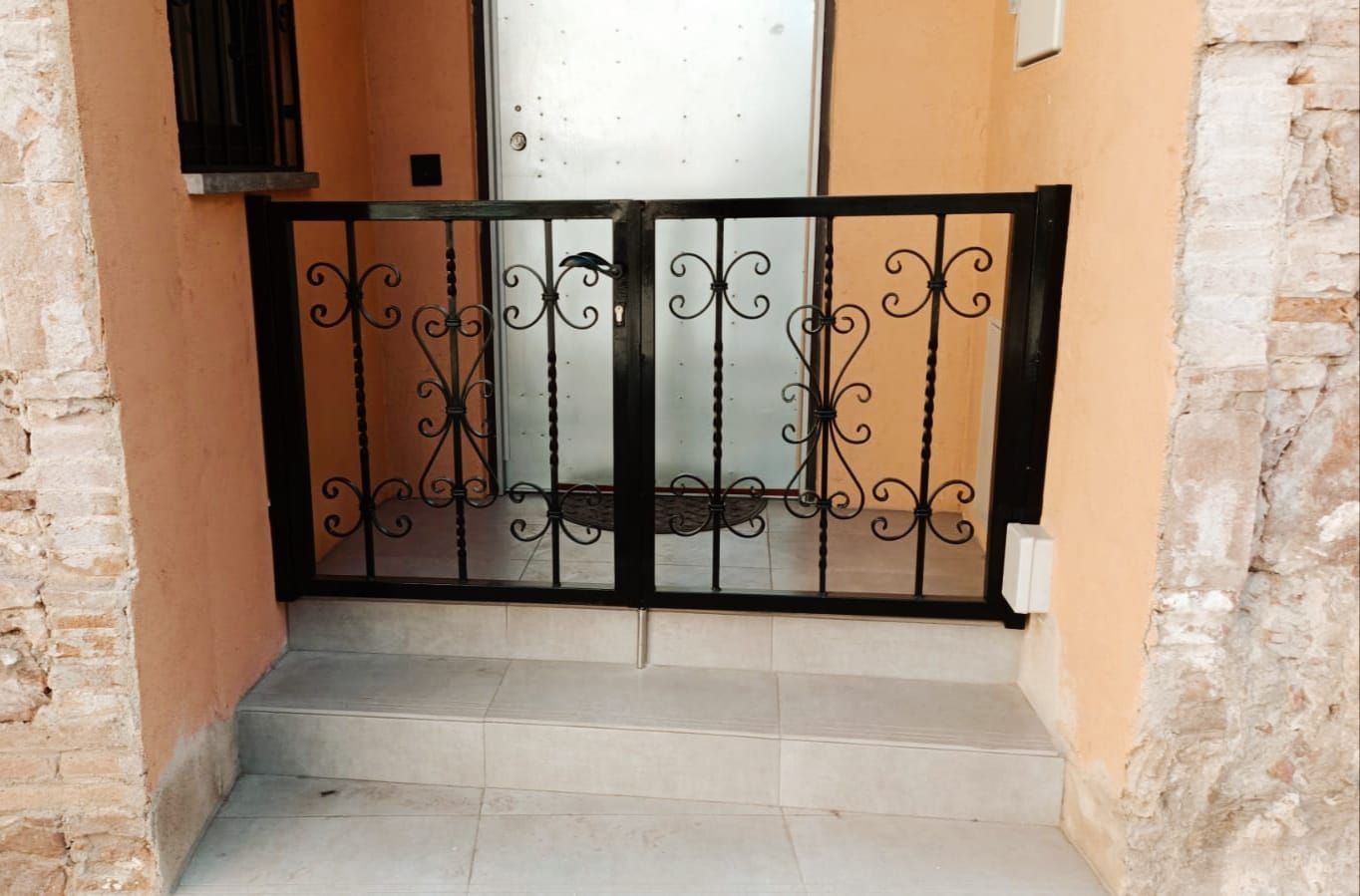 Una puerta de hierro forjado delante de una puerta