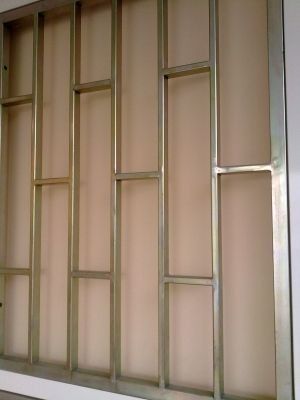 Un marco de metal está colocado en una pared al lado de una ventana.