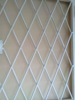 Un primer plano de una celosía blanca en una pared.