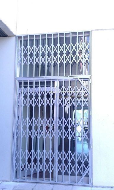 Un edificio blanco con una puerta de metal en el costado.