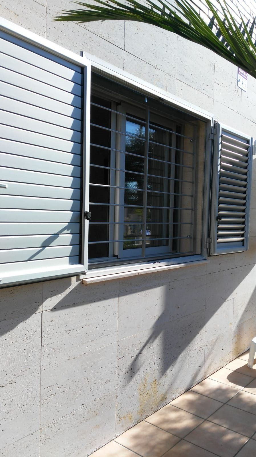 Una ventana con contraventanas está en el costado de un edificio.