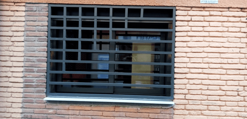 Un edificio de ladrillo con una ventana con rejas.