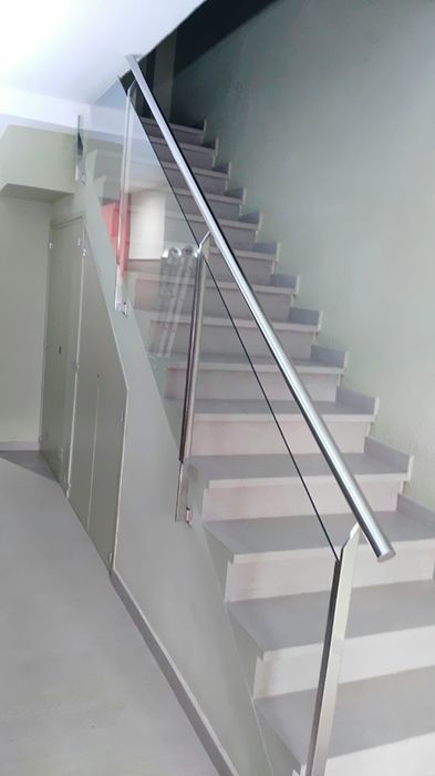 Una escalera con barandilla de cristal y barandilla de acero inoxidable.