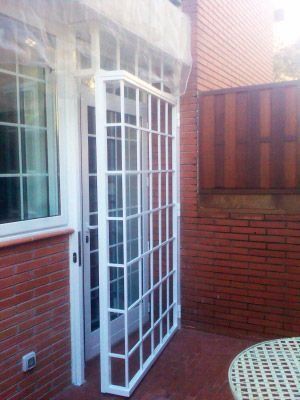 Una puerta blanca con una pared de ladrillos detrás.