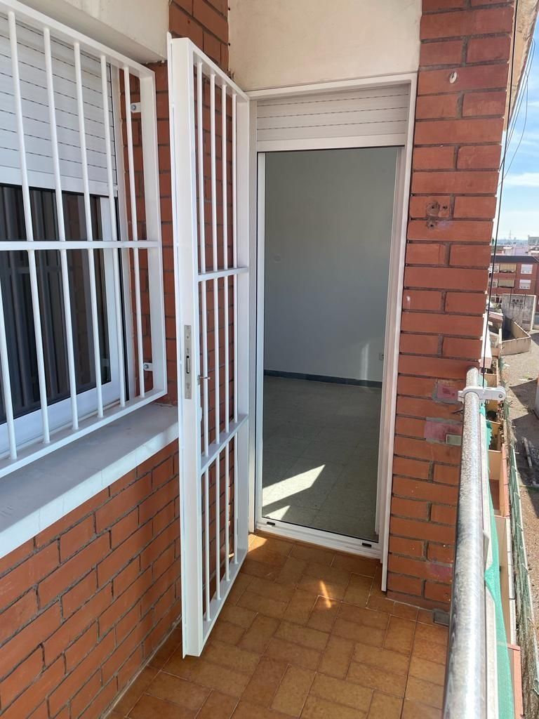 Un edificio de ladrillo con una puerta blanca y una ventana.
