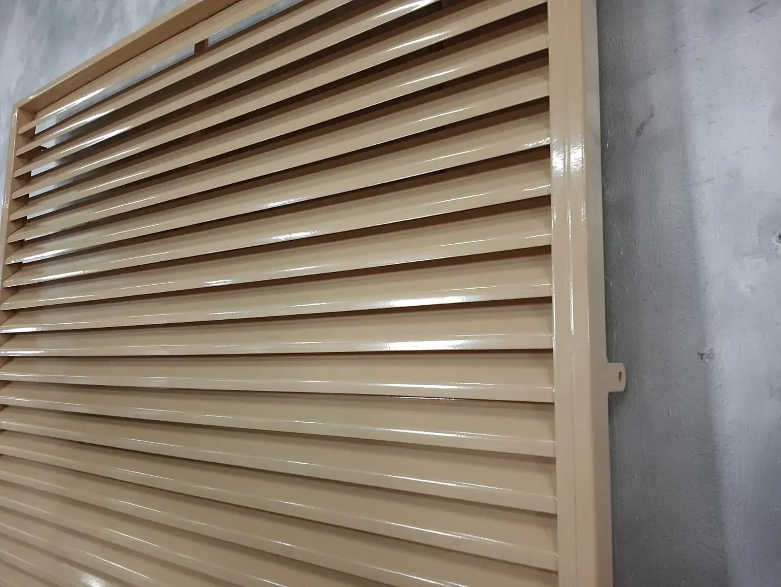 Un primer plano de una persiana de color canela en una pared.