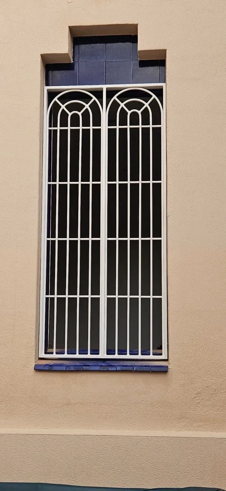 Una ventana con una reja de metal está en un edificio.