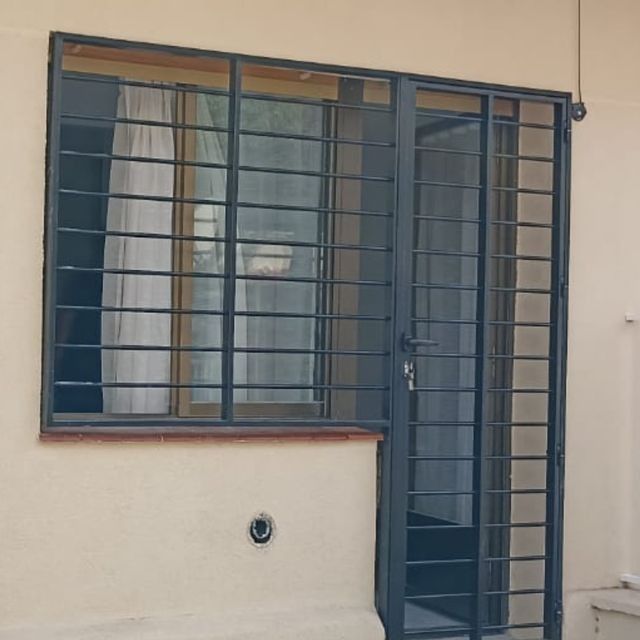 Una ventana con rejas alrededor y una puerta