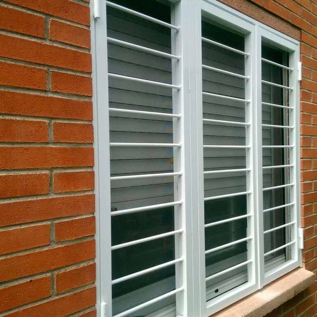 Una ventana con rejas está en una pared de ladrillos.
