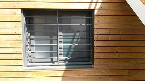 Un edificio de madera con una ventana con rejas.