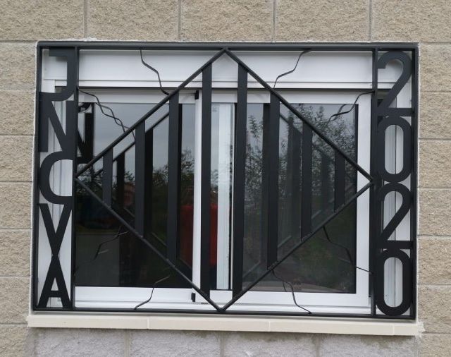 Una ventana con una reja de hierro forjado que dice nc.