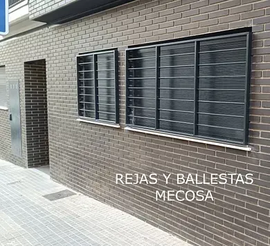 Un edificio de ladrillo con ventanas negras y una puerta.