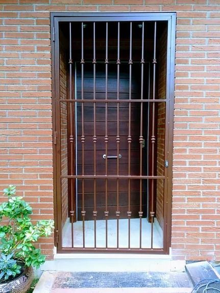 Una puerta con una verja de hierro forjado alrededor