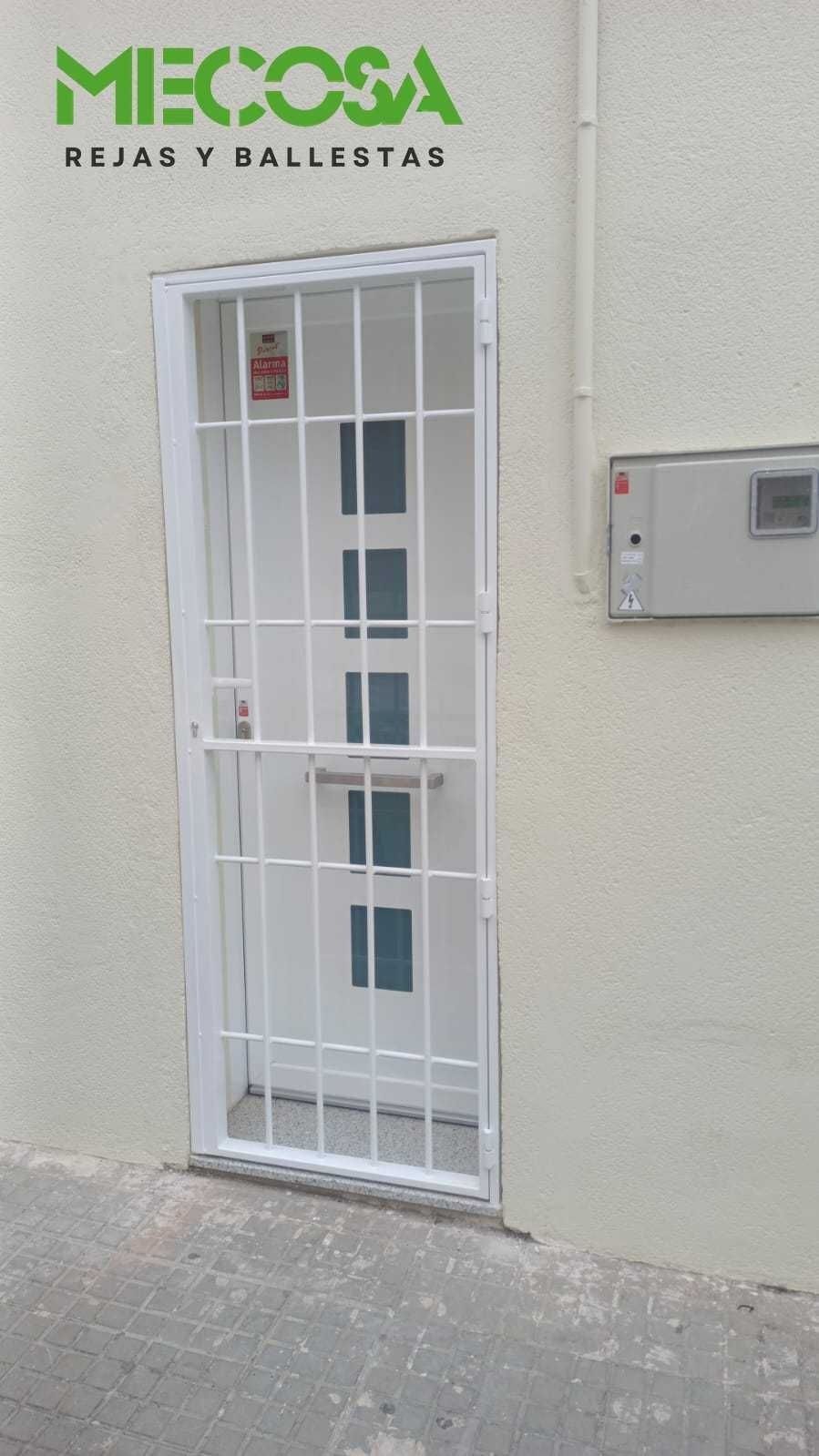 Una puerta blanca con una reja alrededor y un cartel que dice mecosa