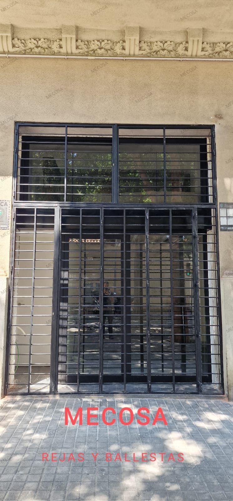 Un edificio con una puerta de metal y escaleras en el frente.