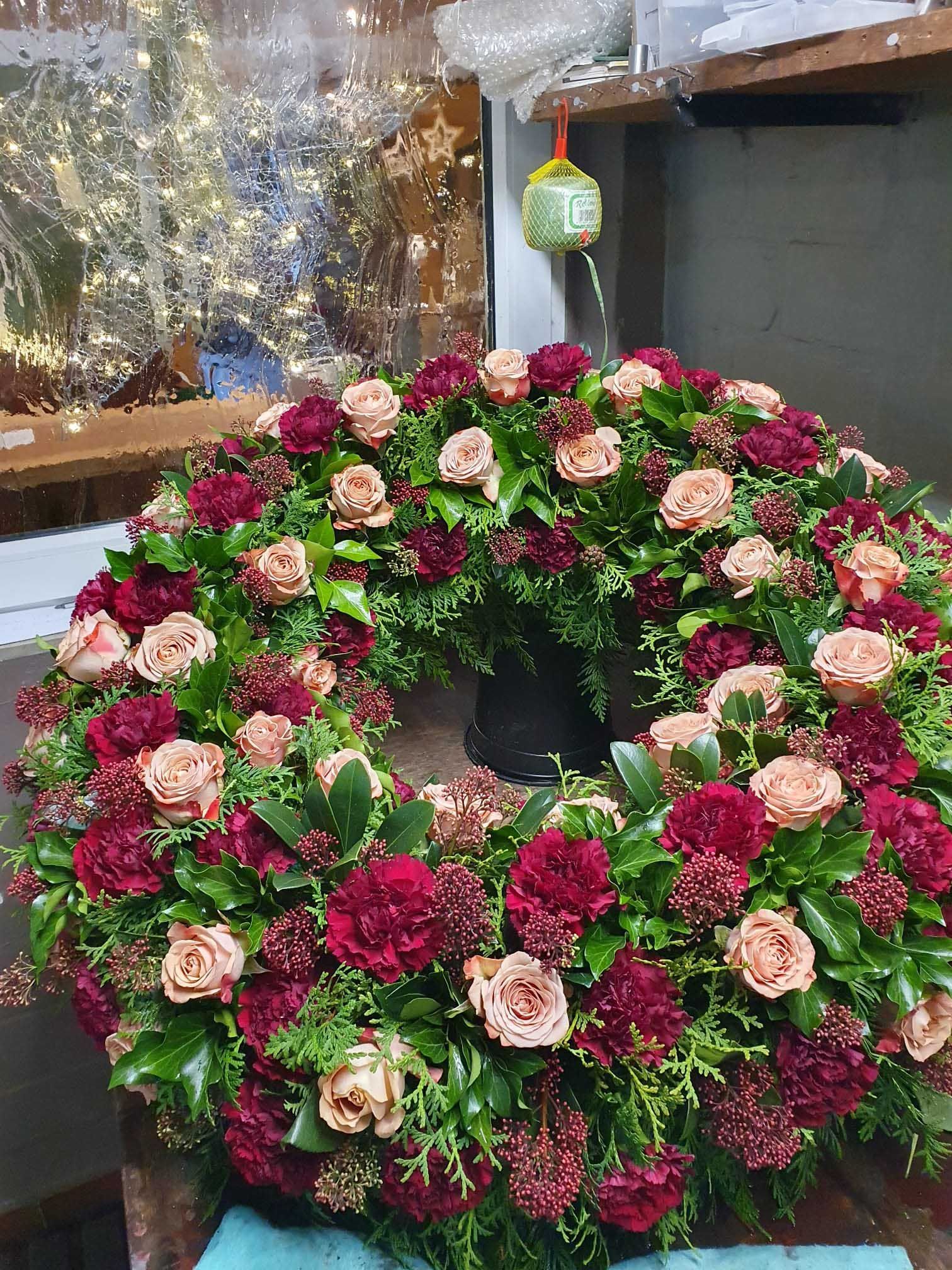 Verschiedene Blumensträuße in unterschiedlichen Farben und Größen, arrangiert mit dekorativen Pflanzen und Blättern.