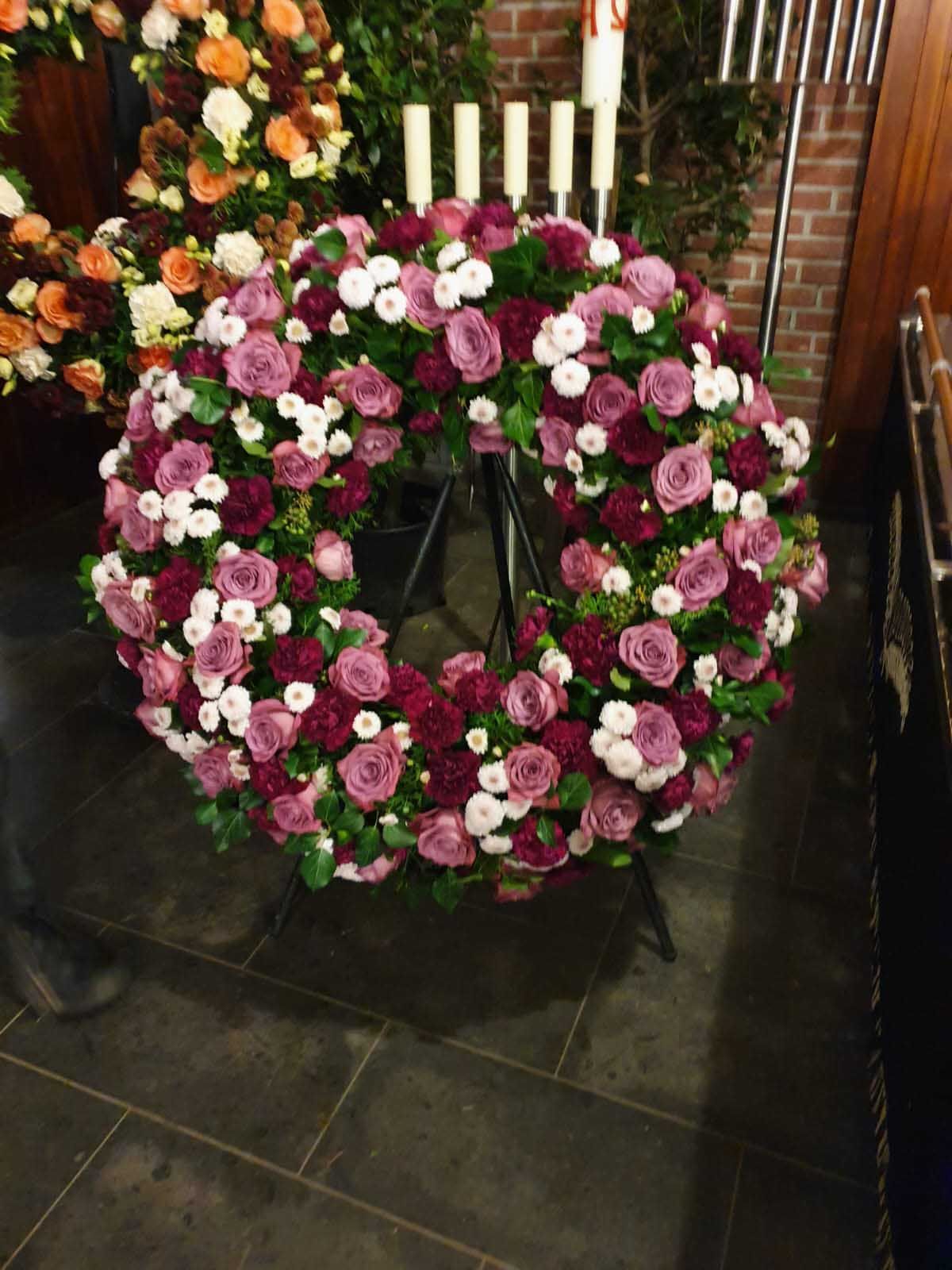 Verschiedene Blumensträuße in unterschiedlichen Farben und Größen, arrangiert mit dekorativen Pflanzen und Blättern.