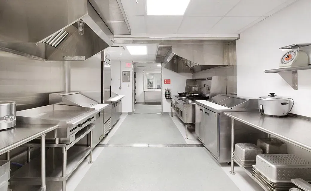 Una persona con una camisa azul limpia el marco superior de una puerta corrediza de vidrio blanca