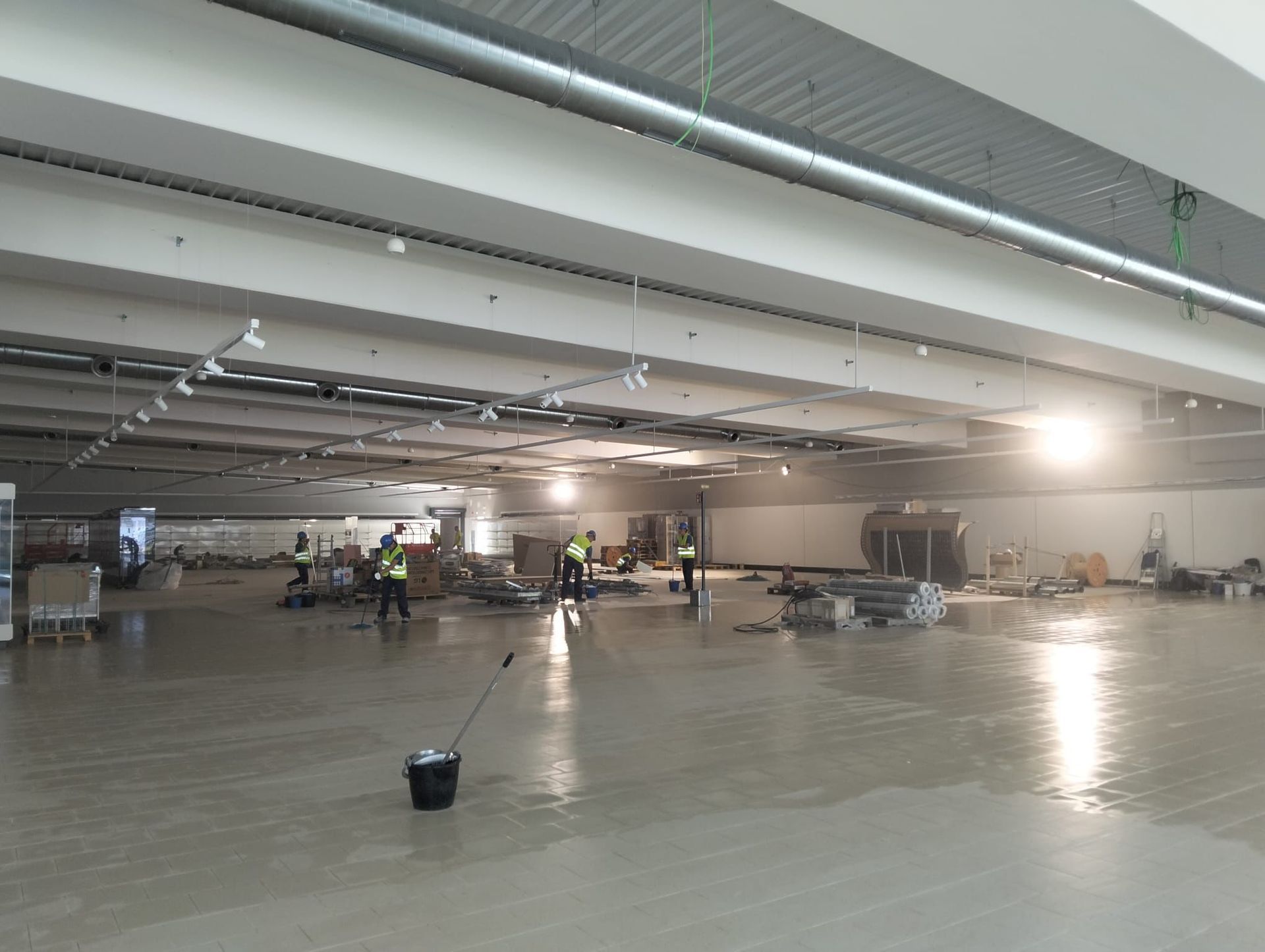 Interior del taller: estantes de madera, herramientas, banco de trabajo, ventana, luz solar.